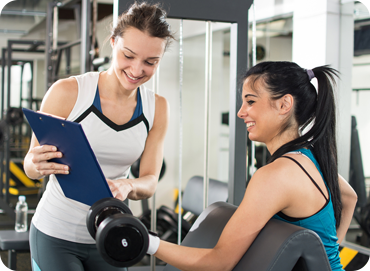 Two people working out and looking at a guide