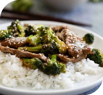 A rice meal with meat and vegetables as toppings